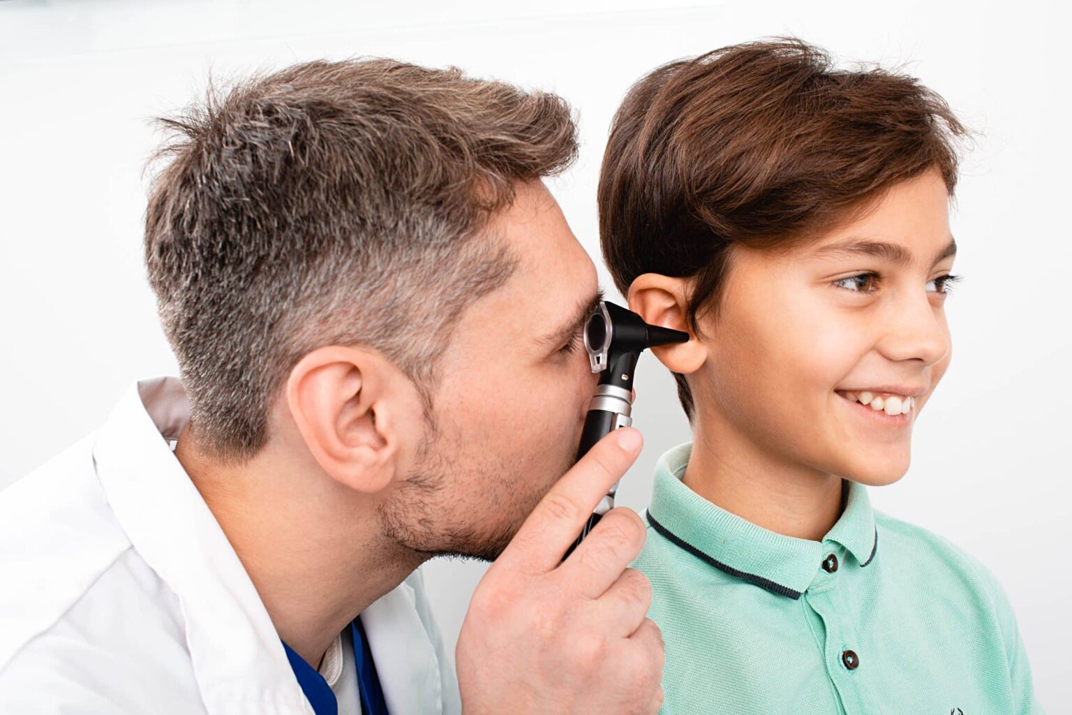 Pediatric-Hearing-Loss-exam Doctor looking inside of a child's ear using a medical instrument