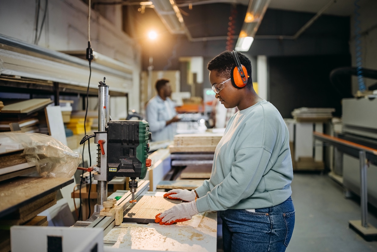 Person wearing earmuffs and working in a woodshop