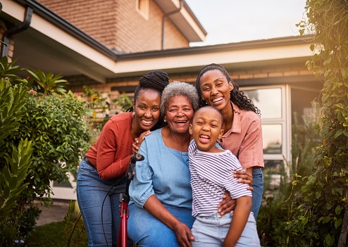 Happy family standing in front of their house.