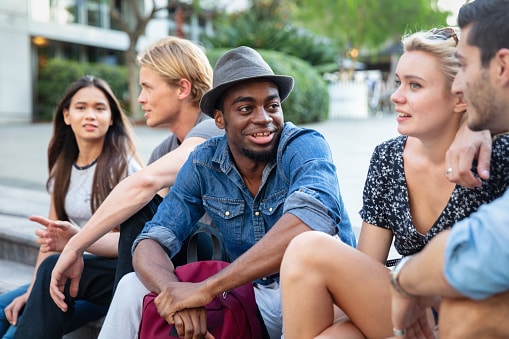 Happy group of friends hanging out outside.
